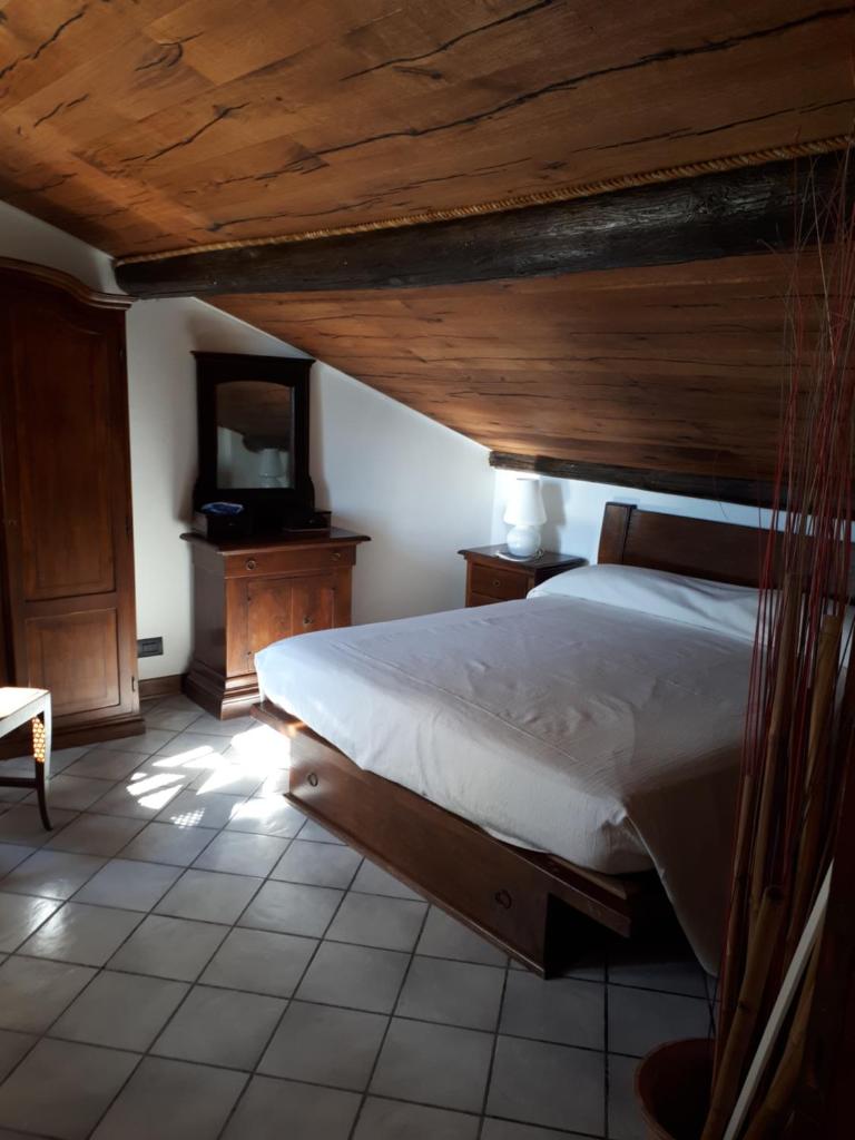 une chambre avec un grand lit avec un plafond en bois dans l'établissement Casa Rea, à Beverino
