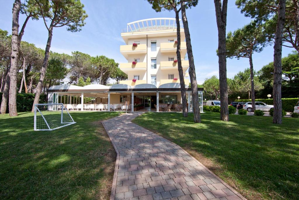 un bâtiment avec un panier de basket dans un parc dans l'établissement Aparthotel La Pineta, à Lido di Jesolo