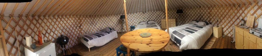 une chambre avec 3 lits dans un bâtiment dans l'établissement Yourtes Mongoles Gavarnie, à Gèdre