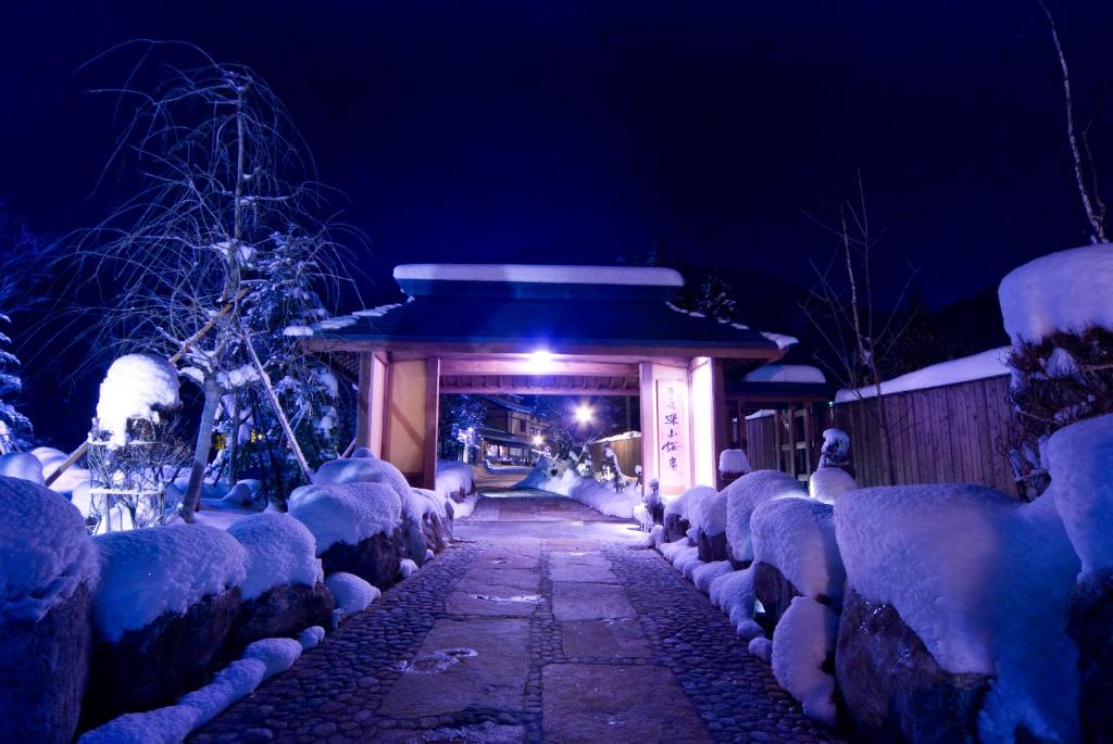 une passerelle couverte de neige la nuit dans l'établissement Miyama Ouan Kyoritsu Resort, à Takayama