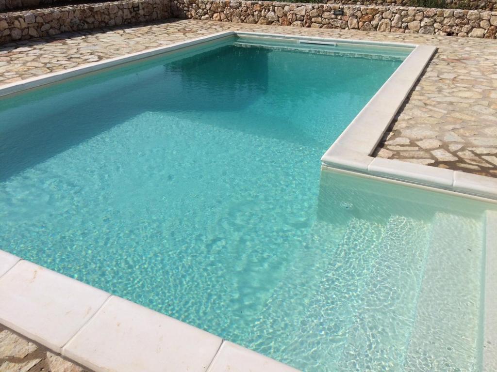 une piscine avec de l'eau bleue dans une cour arrière dans l'établissement Villa Limone, à Castellammare del Golfo