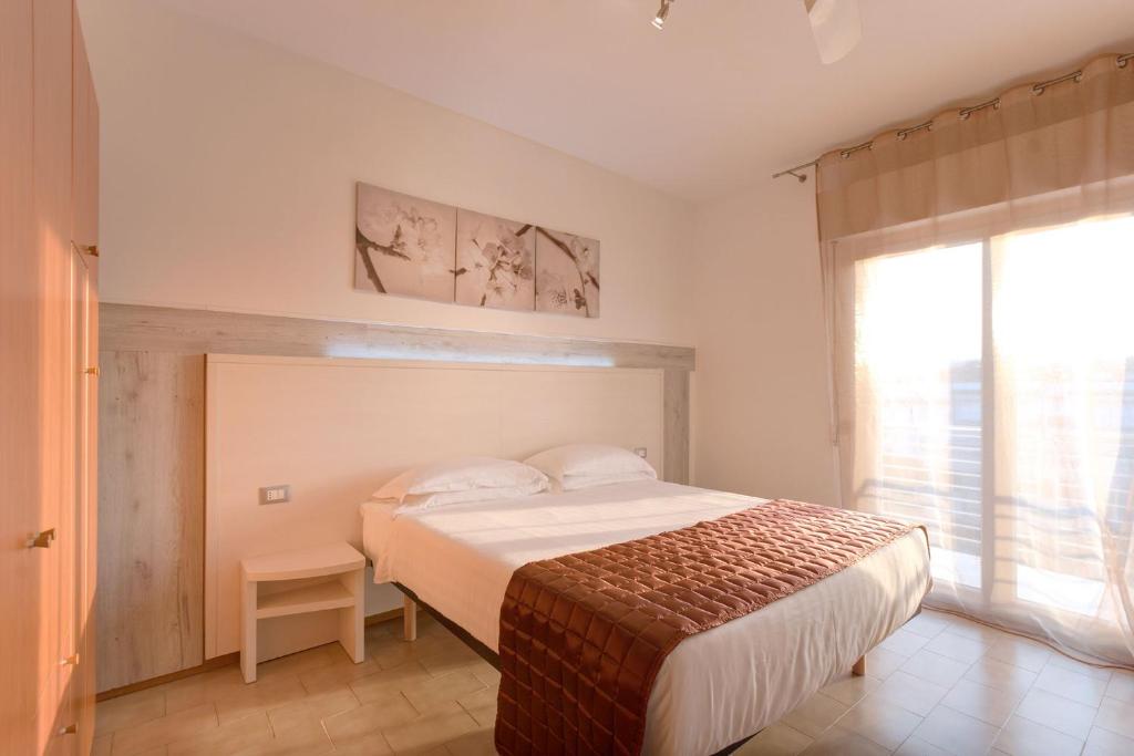 une chambre avec un lit et une grande fenêtre dans l'établissement Il Conero Mare, à Numana