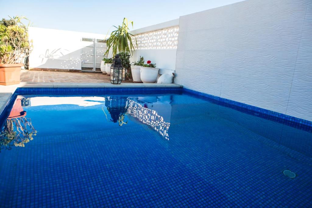 - une piscine avec du carrelage bleu sur le côté d'une maison dans l'établissement Dar Kika Salam By DKS, à Rabat
