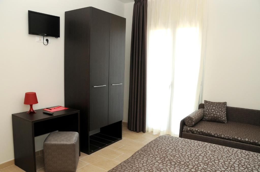 - un salon avec une armoire noire et une chaise dans l'établissement Hotel Morena, à Lido di Jesolo