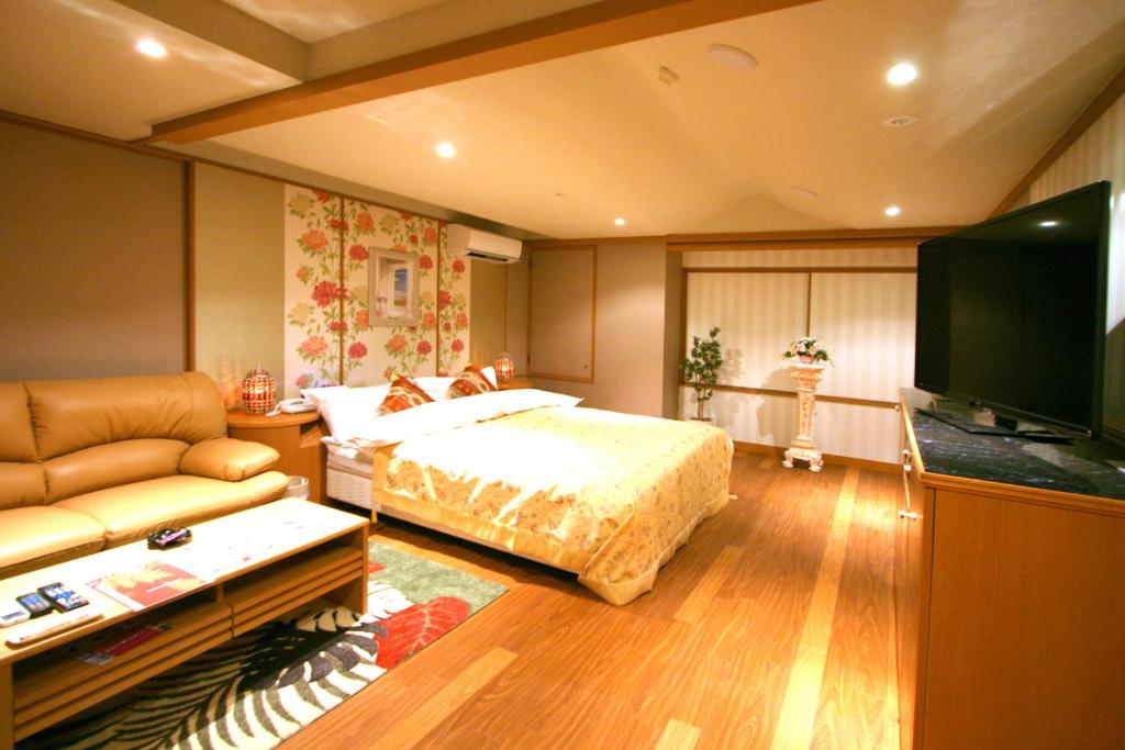 une chambre avec un lit et une télévision à écran plat dans l'établissement AURA Resort Iga (Adult Only), à Iga 8 autres photos