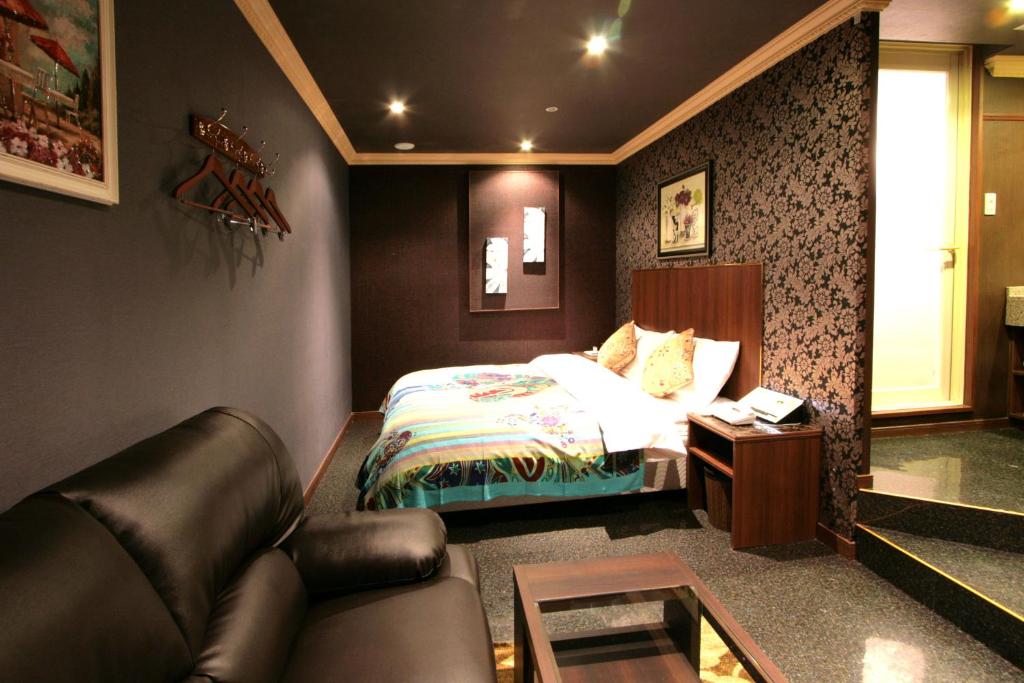 une chambre avec un lit, un canapé et une table dans l'établissement SARI Seki Inter (Adult Only), à Kameyama 14 autres photos