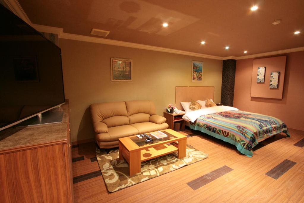 une chambre avec un lit, un canapé et une table dans l'établissement SARI Seki Inter (Adult Only), à Kameyama