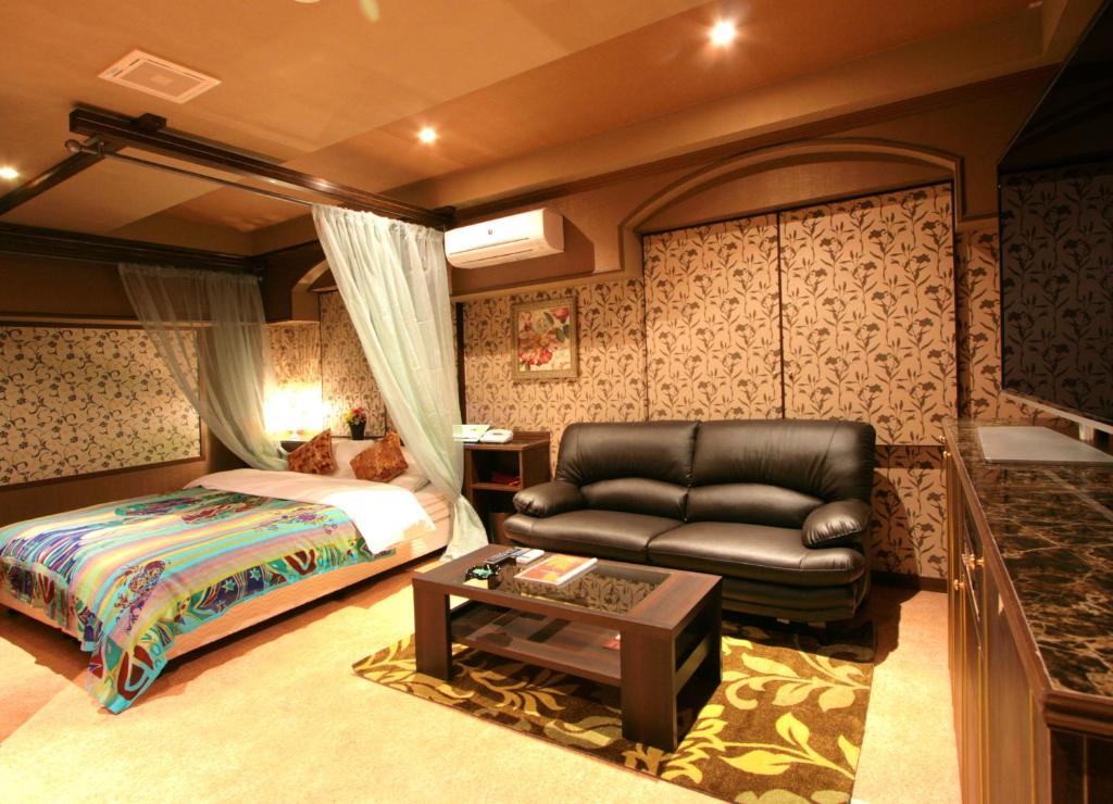 une chambre avec un lit, un canapé et une table dans l'établissement SARI Seki Inter (Adult Only), à Kameyama