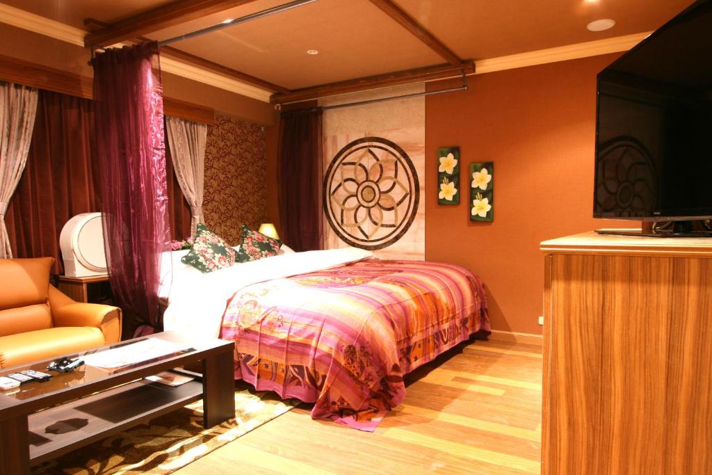 une chambre avec un lit, une télévision et un canapé dans l'établissement AURA Seki Inter (Adult Only), à Kameyama