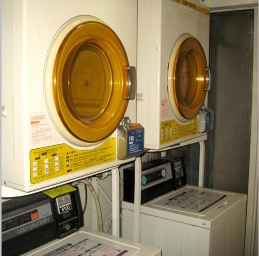 trois micro-ondes sont sur une étagère dans une cuisine dans l'établissement Aspen Shiga, à Yamanouchi