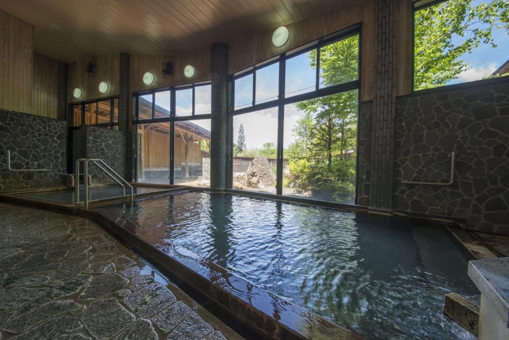 - une grande piscine d'eau dans une chambre avec fenêtres dans l'établissement Nakamurakan, à Takayama