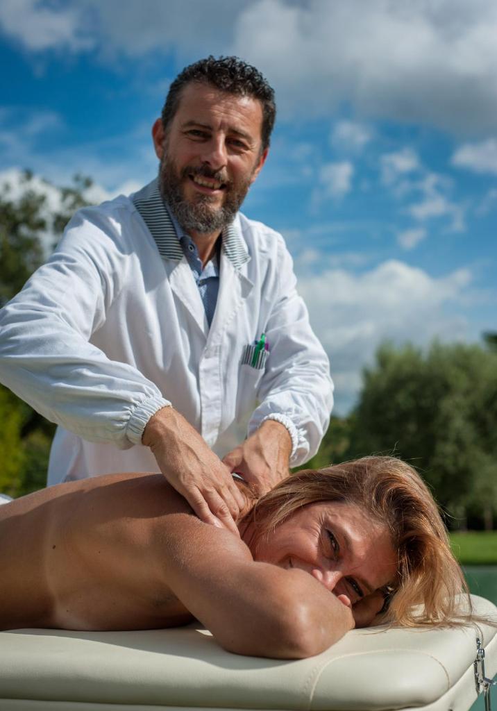 une femme recevant un massage d'un thérapeute dans l'établissement Casa Viale dei Cipressi, à Sovicille