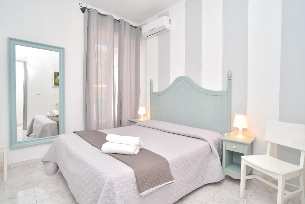 une chambre avec un lit avec un miroir et une chaise dans l'établissement Charme Hotel La Villa Tina, à Ischia