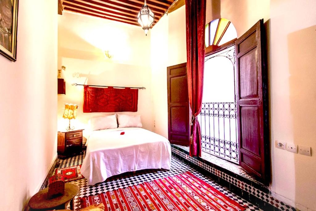 une chambre avec un lit et une grande fenêtre dans l'établissement Dar Nineta, à Fès
