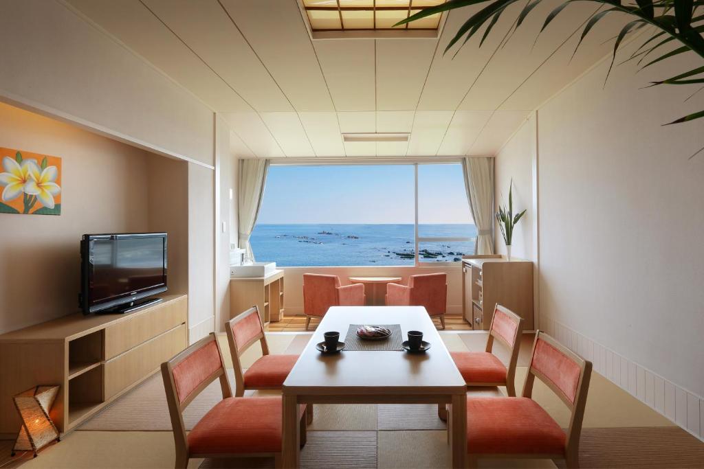 une pièce avec une table, des chaises et une télévision dans l'établissement Shirahama Ocean Resort, à Minamiboso