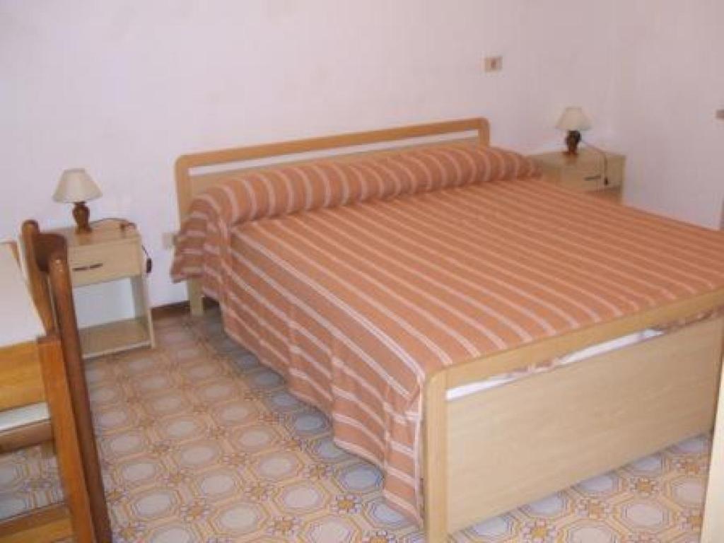une chambre avec un lit et deux tables de nuit dans l'établissement Giannella Appartamenti, à Orbetello