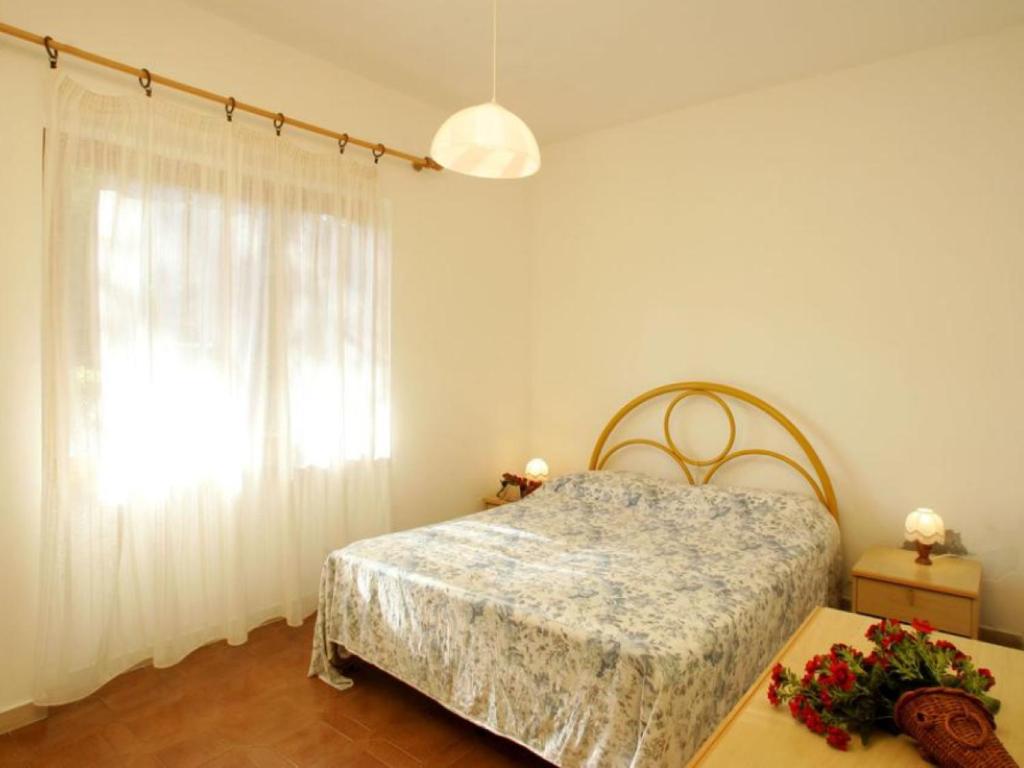 une chambre avec un lit et une fenêtre dans l'établissement Giannella Appartamenti, à Orbetello
