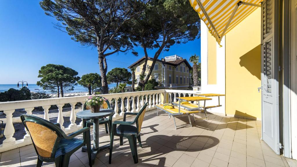 d'un balcon avec des tables et des chaises et une vue sur l'océan. dans l'établissement Hotel Ville Bianchi, à Grado