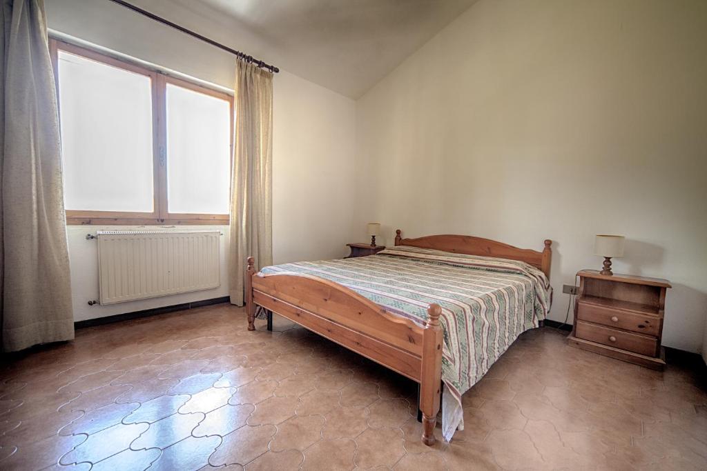 une chambre avec un lit et une grande fenêtre dans l'établissement Giannella Appartamenti, à Orbetello