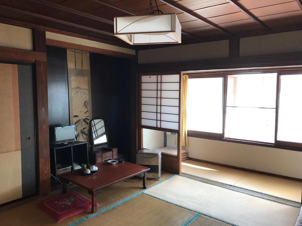 - un salon avec une table et 2 fenêtres dans l'établissement Niko Ryokan, à Aizuwakamatsu
