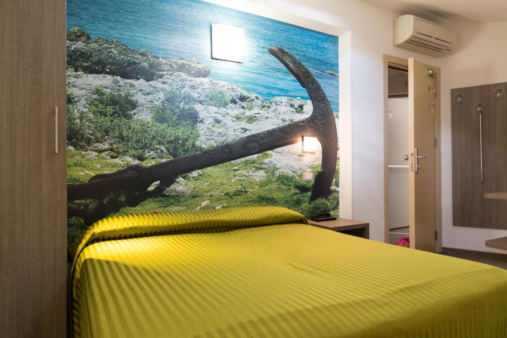 une chambre avec un lit jaune avec un tableau sur le mur dans l'établissement Hotel Miramare, à Pineto