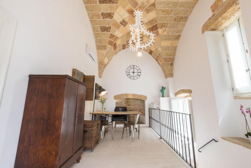 une salle à manger avec une table et un lustre dans l'établissement Le Sei Conche Relais & SPA, à Gemini