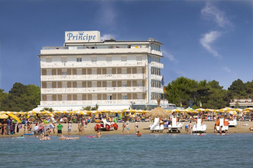 un hôtel sur une plage avec des gens sur la plage dans l'établissement Hotel Principe, à Caorle