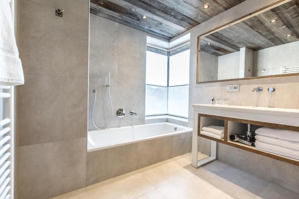 une salle de bain avec une baignoire, une douche et un lavabo dans l'établissement Hôtel Spa Crychar, aux Gets