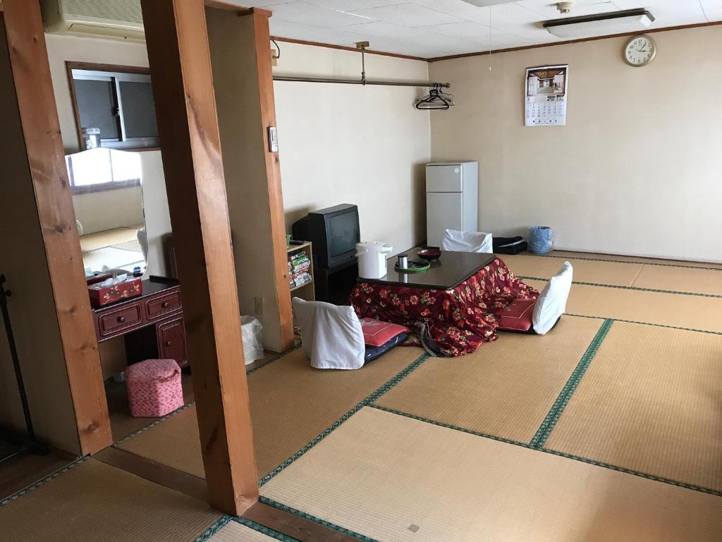 un salon avec une table et une cuisine dans l'établissement Niko Ryokan, à Aizuwakamatsu