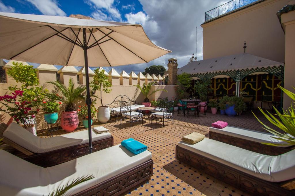 - une terrasse avec 2 canapés et un parasol dans l'établissement Riad Fes Baraka, à Fès 37 autres photos