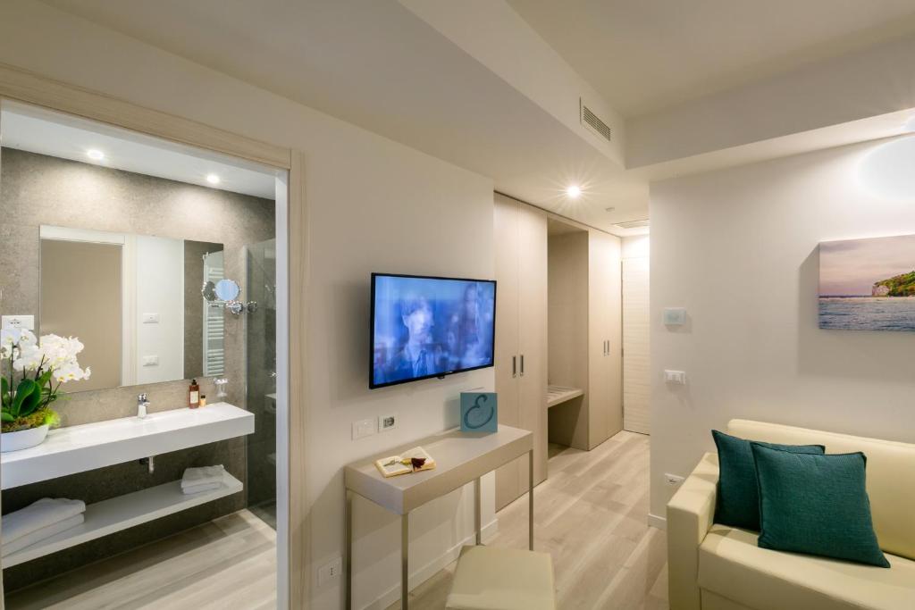 un salon avec un canapé et une télévision sur un mur dans l'établissement Hotel Europa, à Sirmione 50 autres photos