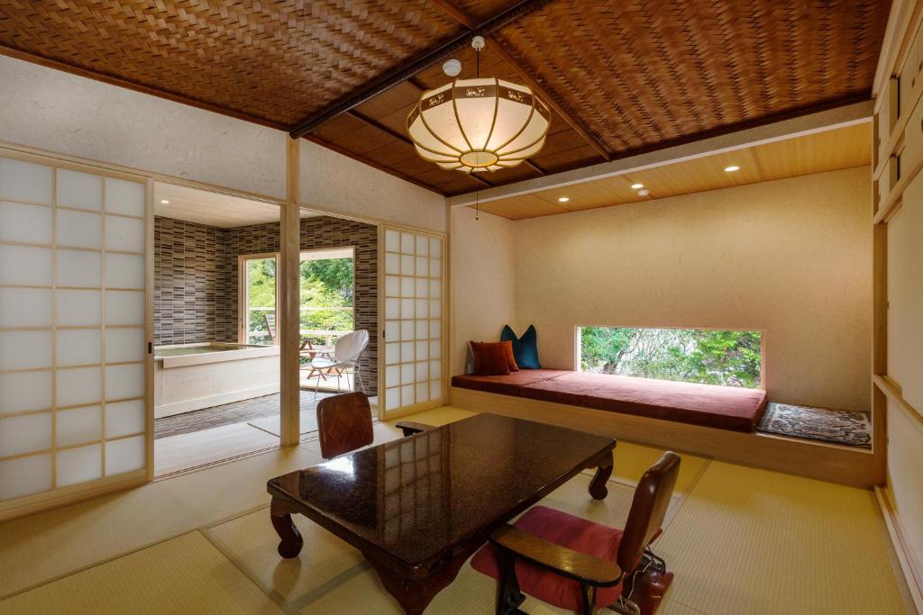 une chambre avec un lit, une table et des chaises dans l'établissement Kyoto Nanzenji Ryokan Yachiyo Established in 1915, à Kyoto