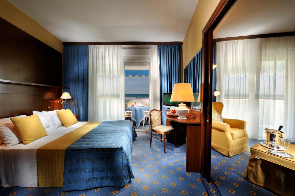 une chambre d'hôtel avec un lit et un bureau dans l'établissement Hotel Corallo, à Bibione 54 autres photos