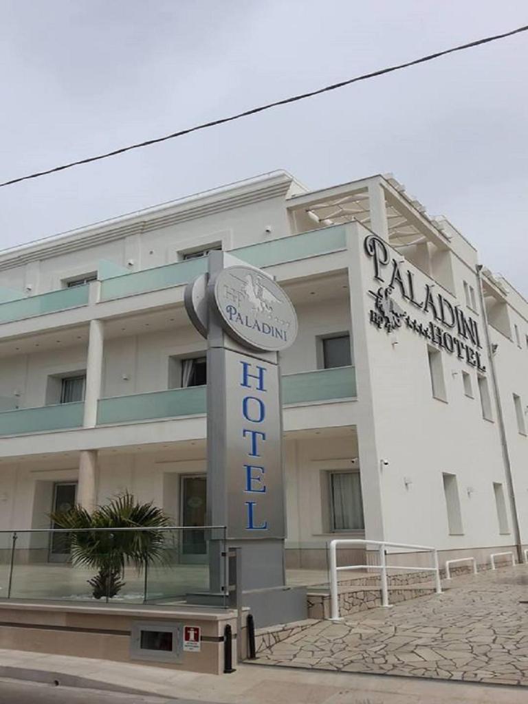 un bâtiment avec une enseigne devant lui dans l'établissement Hotel Paladini, à Porto Cesareo