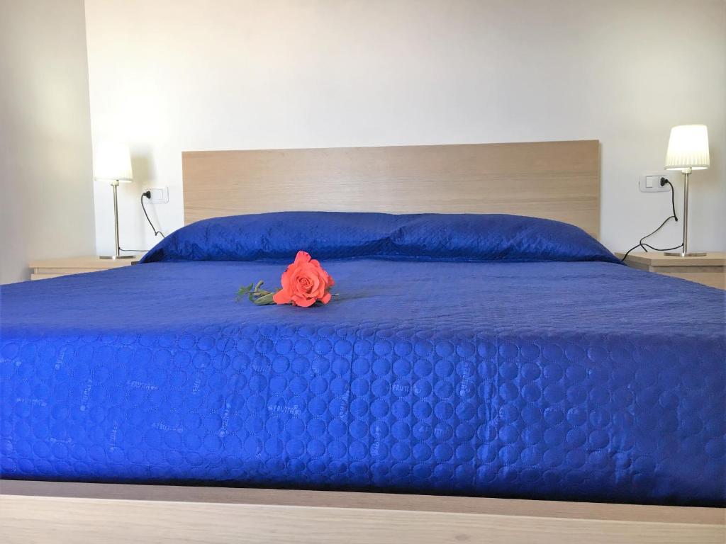 une rose rouge assise au-dessus d'un lit bleu dans l'établissement Maison Marie, à Vieste
