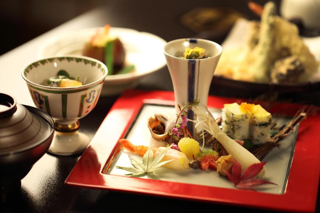 une assiette de nourriture sur une table avec deux tasses dans l'établissement Chigira Jinsentei, à Shibukawa