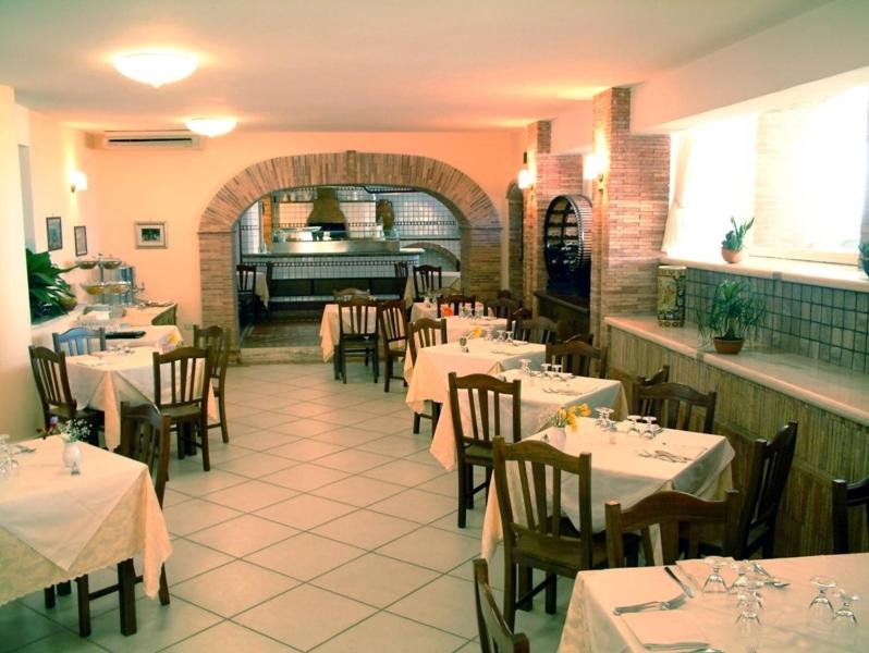 un restaurant avec des tables et des chaises avec une nappe blanche dans l'établissement New Hotel Sonia, à Santa Maria di Castellabate