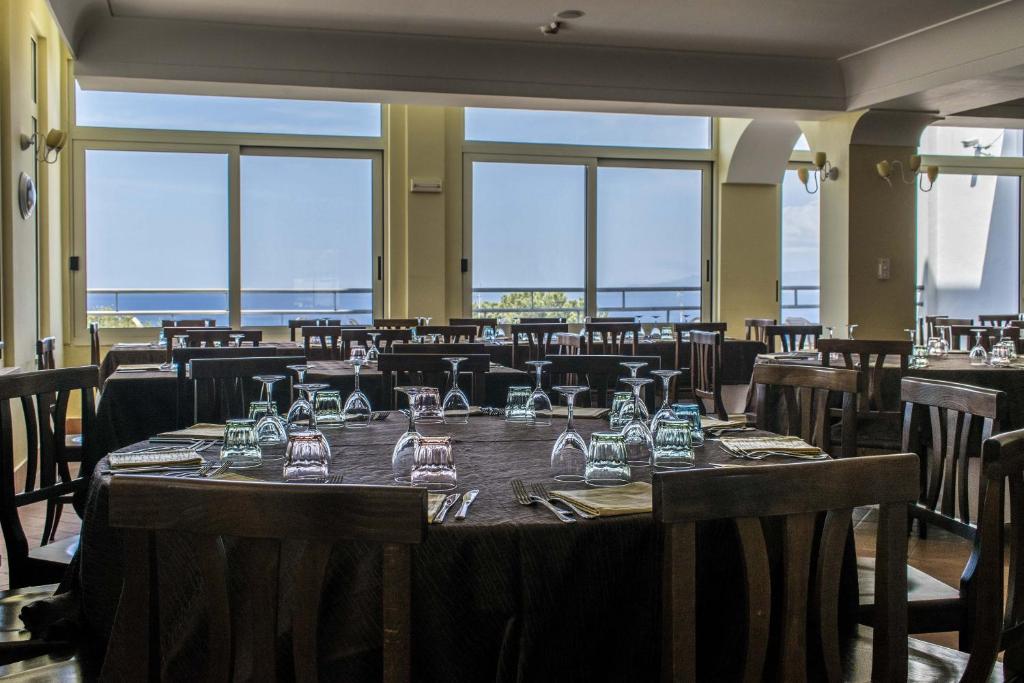 - une salle à manger avec une table et des verres dans l'établissement Hotel Baia, à Palinuro