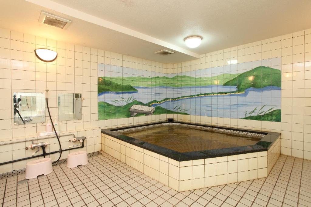 La salle de bains est pourvue d'une grande baignoire au milieu. dans l'établissement Hotel Tango Nakamura So, à Miyazu