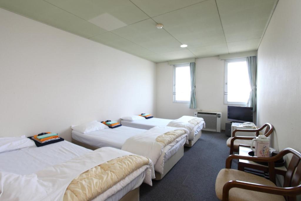 Cette chambre comprend 4 lits et une télévision. dans l'établissement Hotel Tango Nakamura So, à Miyazu