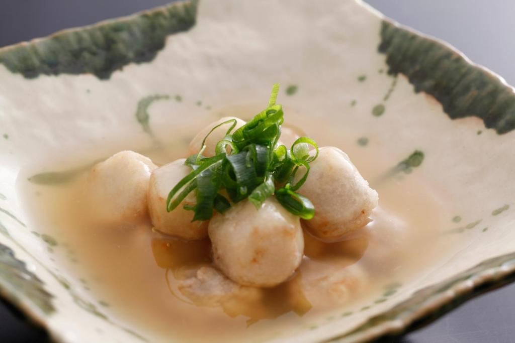 une assiette de nourriture avec des coquilles Saint-Jacques dans une sauce dans l'établissement Hotel Tango Nakamura So, à Miyazu 20 autres photos