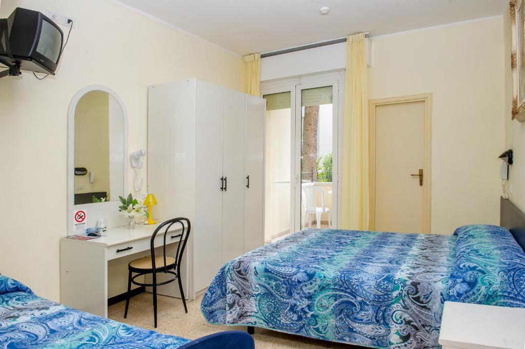 une chambre avec un lit, un bureau et un miroir dans l'établissement Hotel Cristina Hospitality Centrale, à Riccione