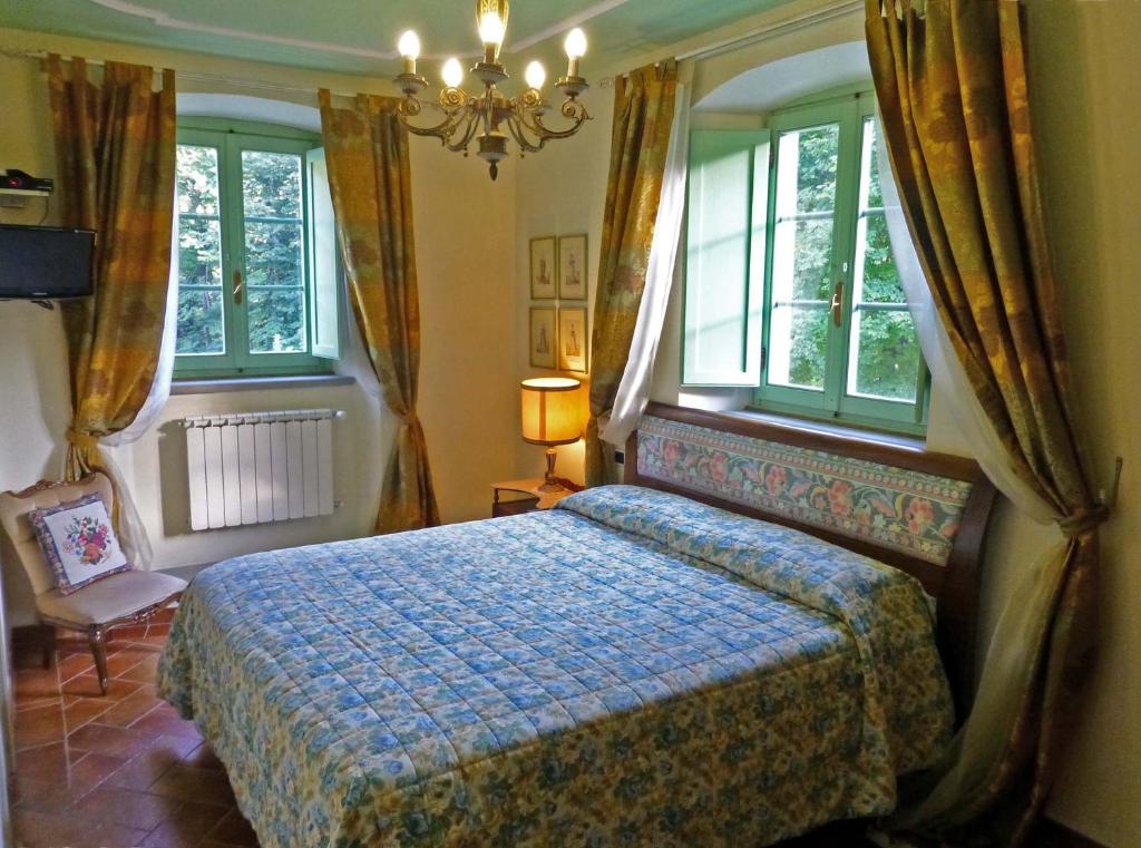 - une chambre avec un lit, des fenêtres et un lustre dans l'établissement Villa Le Panche, à Pontepetri