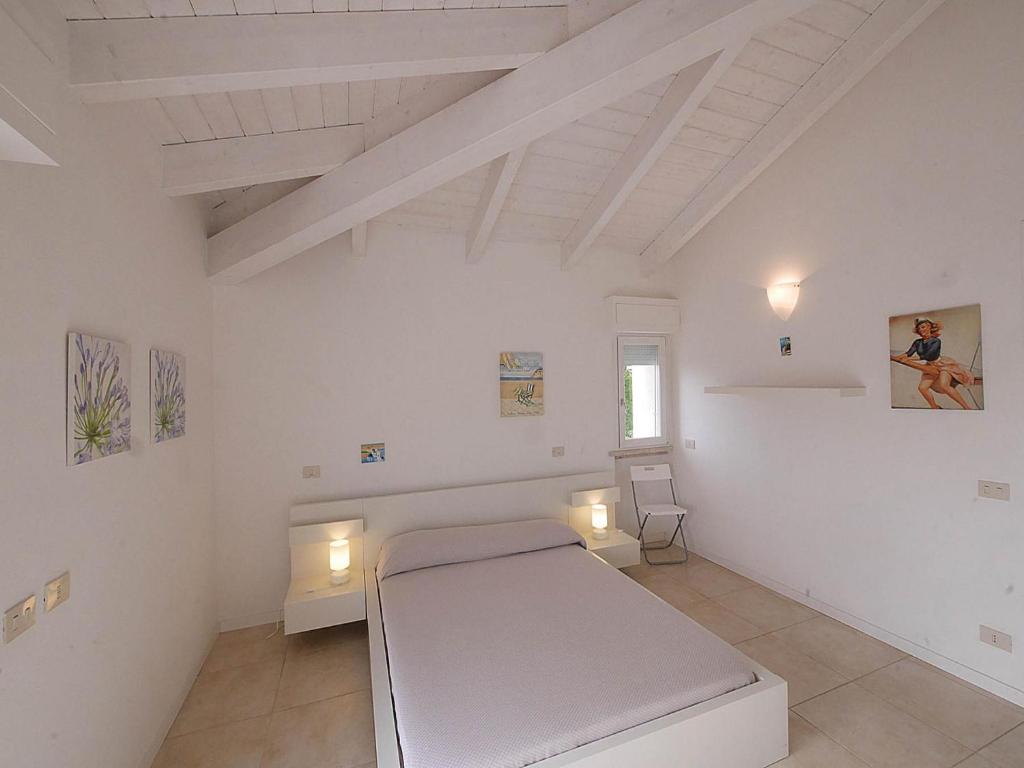 une chambre blanche avec un lit et une fenêtre dans l'établissement Residence Villa Livia, à San Vincenzo