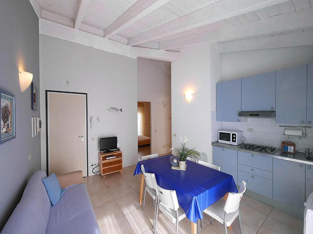 un salon avec une table bleue et une cuisine dans l'établissement Residence Villa Livia, à San Vincenzo