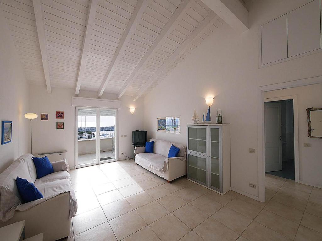 Elle comprend un salon doté d'un mobilier blanc et d'un plafond blanc. dans l'établissement Residence Villa Livia, à San Vincenzo