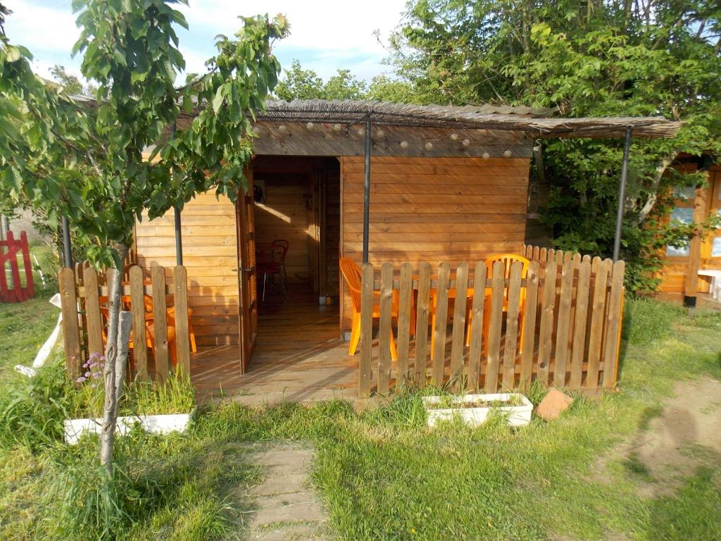 une cabane en bois avec des chaises en face de celle-ci dans l'établissement Yourte mongole, à Huriel