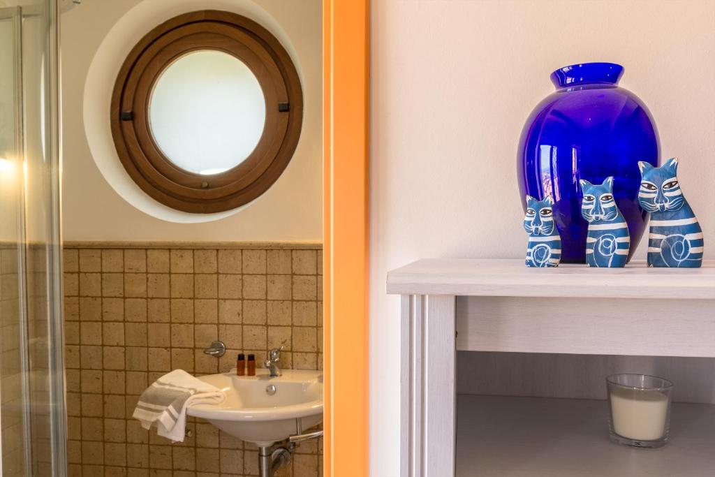 La salle de bains est pourvue d'un vase bleu et d'un lavabo. dans l'établissement Villa Battiato . Home n Pool, à Acireale