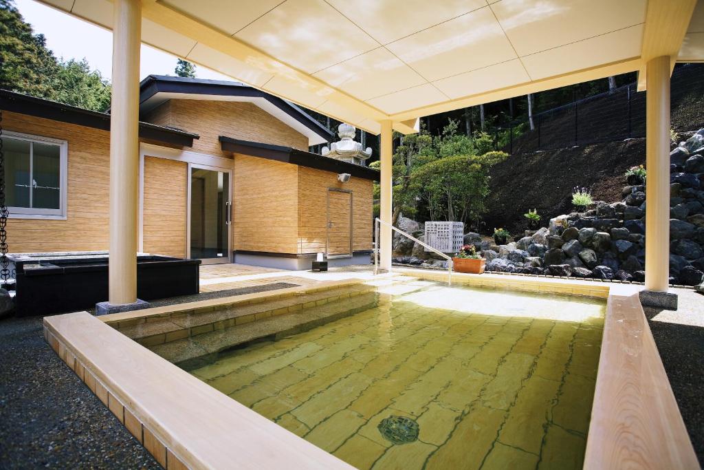 une maison avec une piscine d'eau dans une cour dans l'établissement Shoenso Hozugawatei, à Kameoka