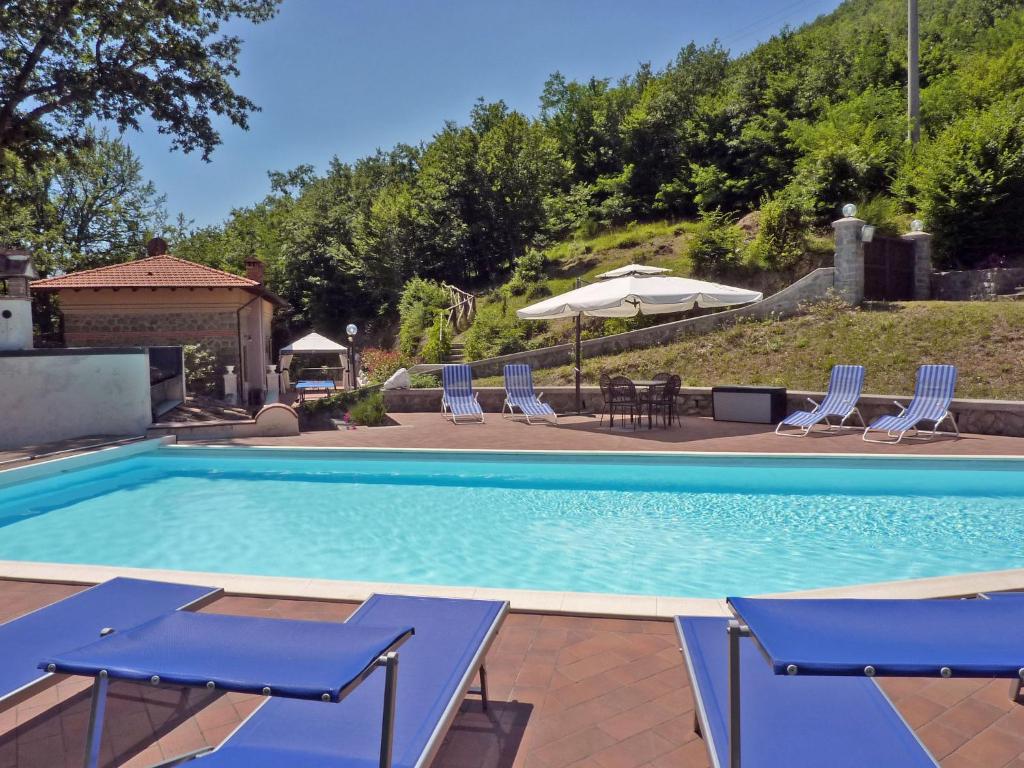- une piscine avec des chaises, une table et des parasols dans l'établissement Villa Morelli Gualtierotti, à Pontepetri